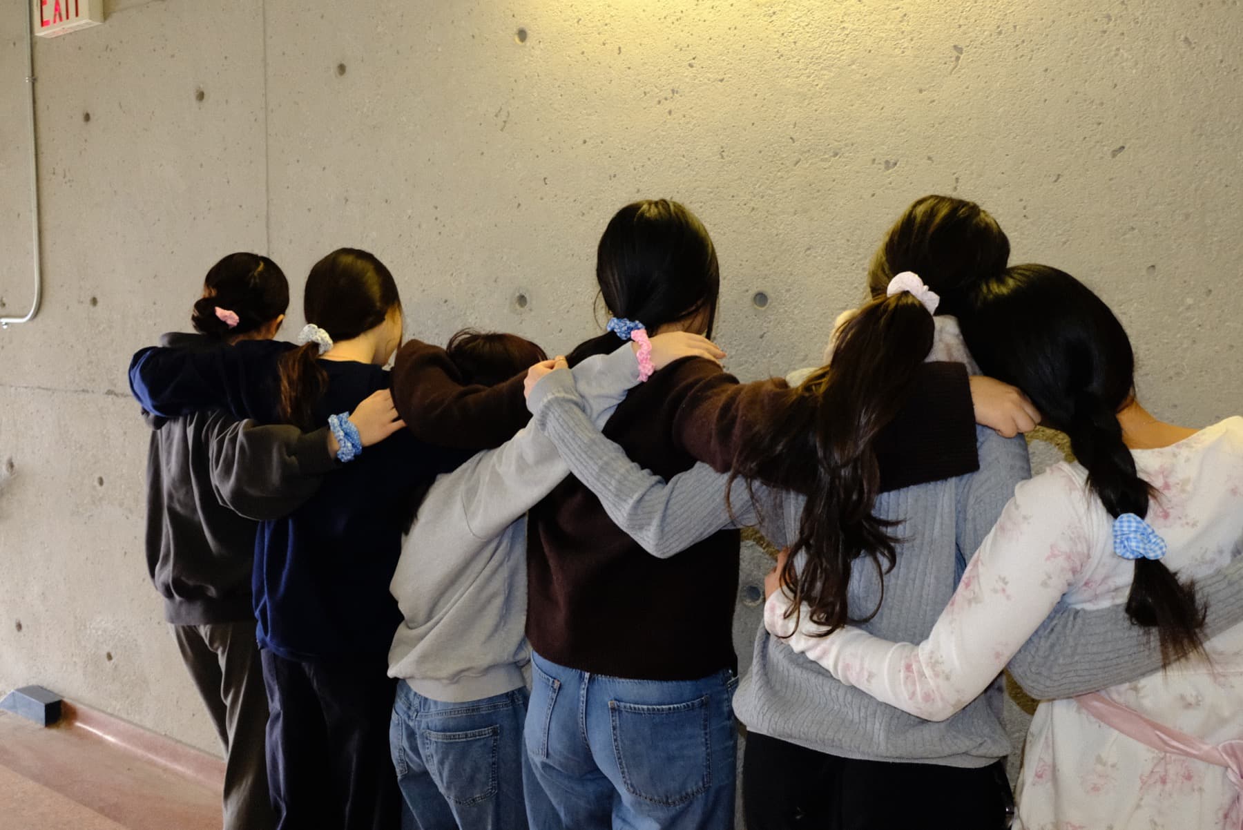 A group of friends with arms around each other, wearing scrunchies